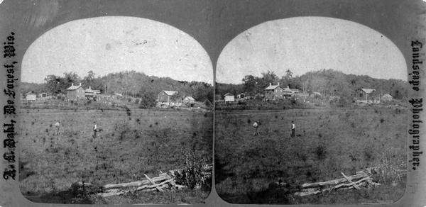 Field in the foreground with log building, barn and house with people in front yard in background.  Mr. Harold Haroldsen Stugaard died in 1875 and his wife, Berit Syverud, continued to farm the property located sec. 21 SE1/4, on Town Hall Road south of Offendahl Road. In 1903 this was the Martin Bang farm, in 1918 the house was moved from its foundation, in 1945 it was owned by John G. Bigler, in 1980 it was owned by Gary Lutz and in 1980 the house was demolished.
