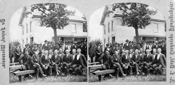 This group portrait was taken in the yard in front of the Immanuel Norwegian Evangelical Lutheran Church parsonage, and is part of a series taken during the meeting of the Eastern District Norwegian Synod.