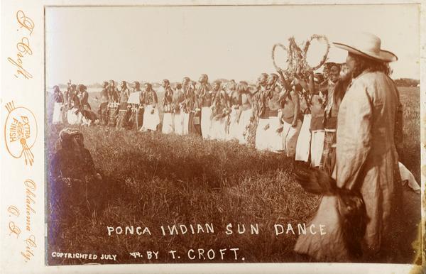 A Ponca Indian Sundance.  The participants are lined up in the grass.
