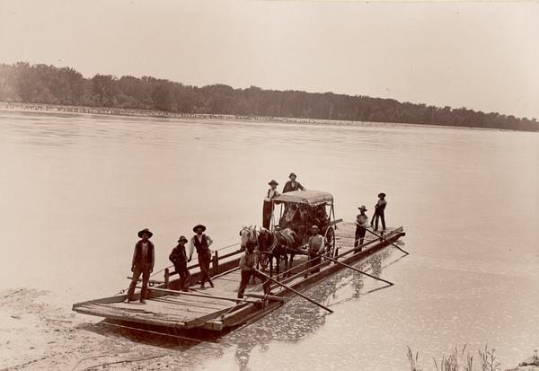 A ferry on the Arkansas River between Muskogee and Ft. Gibson.  Passengers include men, women, and horses.