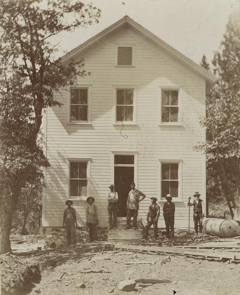 Workers stand in front of a new laundry building at the Greenville Indian School.