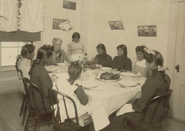 Women and girls dine around a table at the Pima Agency, near Phoenix.