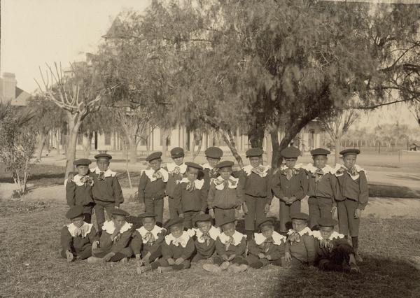 A group of uniformed children pose on agency grounds.