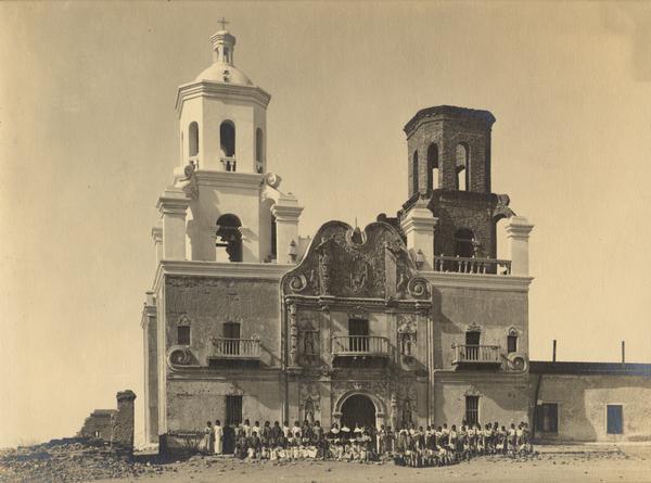 An unidentified group of Indians in front of the San Xavier Mission Church, nine miles from Tucson.