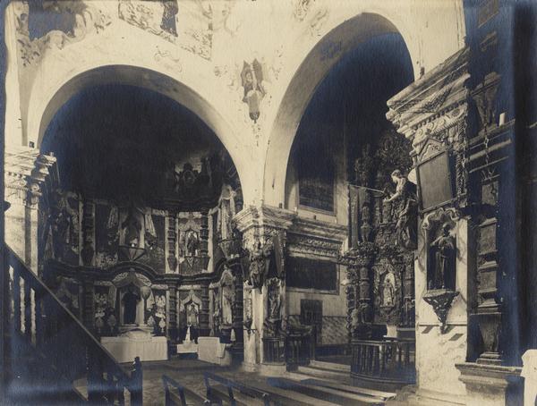 An interior view of the San Xavier Del Bac Mission church, showing an altar and the side of an altar area, near Tucson.
