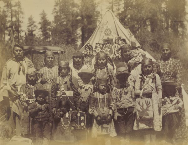 Indian families stand in front of a teepee at the Warm Springs Agency in Oregon.