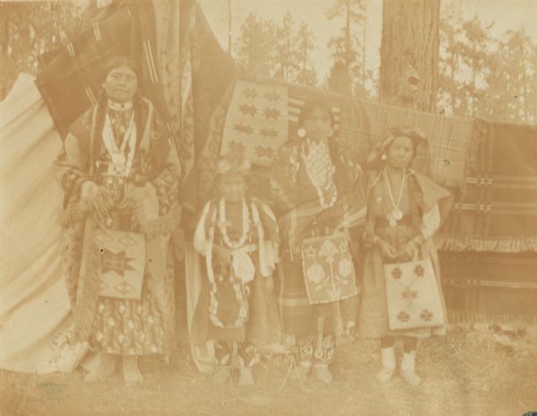 Three women and one girl in full dress at the Warm Springs Agency in Oregon.