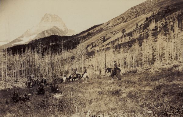 Men on horse back, possibly near the Red Eagle Mountain at St. Mary's Lake.