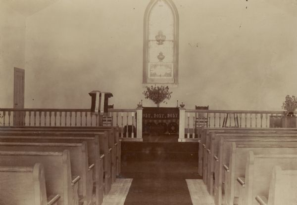 View down center of aisle between pews of altar of St. John's Mercer Memorial Chapel.
