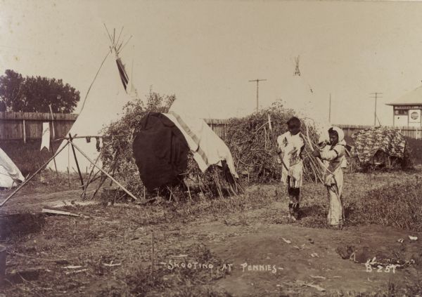 Children shoot at pennies with arrows at the Trans-Mississippi Exposition and Indian Congress.