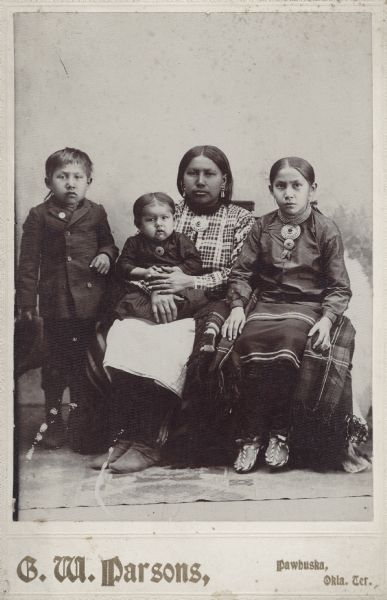 An Osage woman sits with three children.