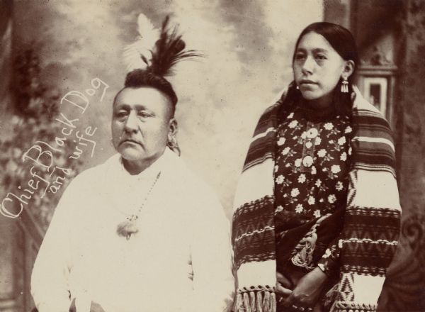 Chief Black Dog and his wife posed in front of a painted backdrop. This image comes from an Osage album with the inscription: "Compliments of G.W. Parsons."