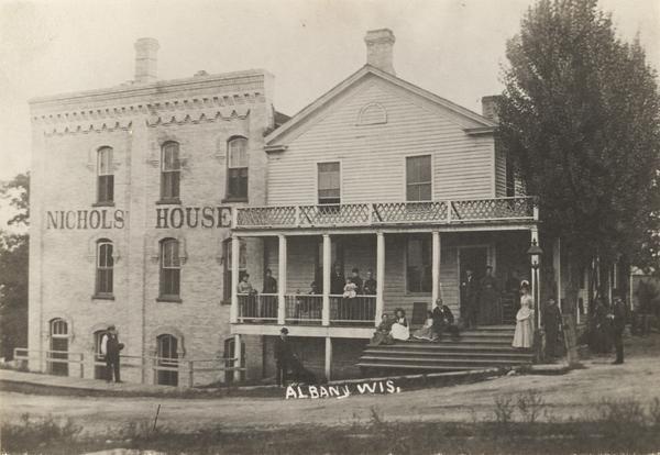 Exterior view of Nichols House with a group of people on and around the porch.