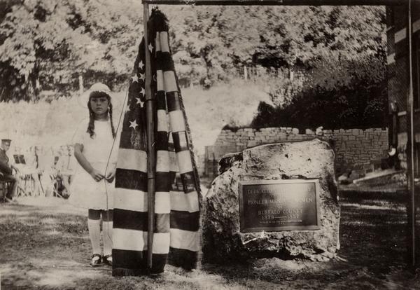Pioneers of Buffalo County memorial marker. Taken during the dedication ceremonies with a young girl standing next to an American flag.