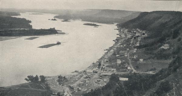 Aerial view of Alma along Mississippi River, with bluffs along the horizon.