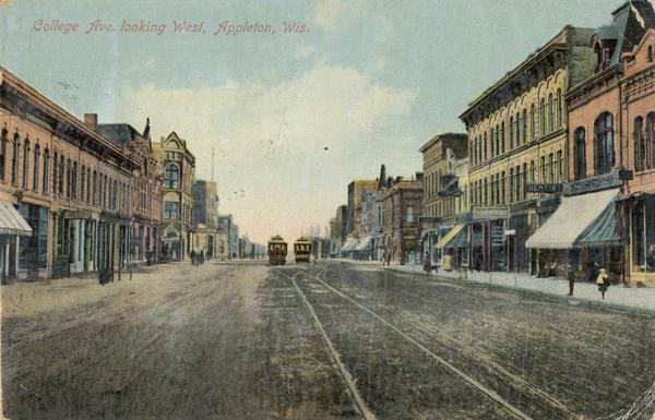 View down College Avenue. Two streetcars are along tracks in the center of the street. Caption reads: "College Ave. looking West, Appleton, Wis."
