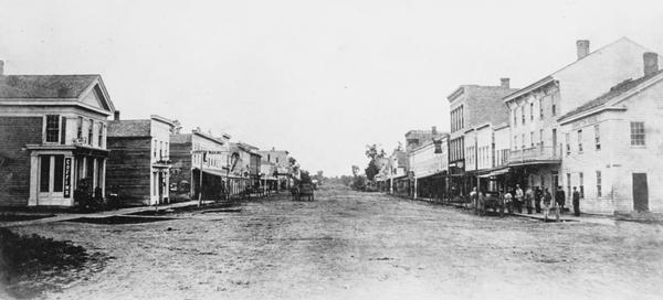 College Avenue looking west from the corner of Morrison Street. The building on the left is the Adkins Building, at the right is the Johnston House. This was later renamed the Levake House.