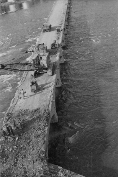 View looking down at people working on John Street Bridge during the razing. There is a crane on the bridge.