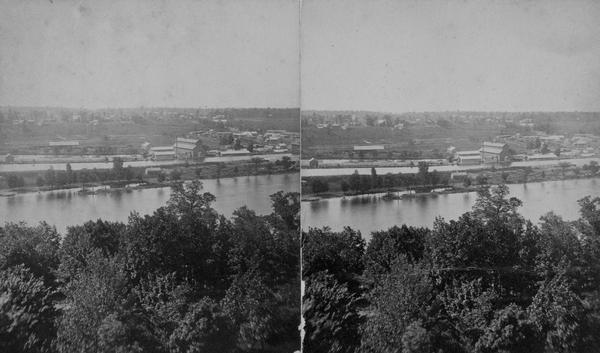Stereograph of elevated view across the river from college grounds.