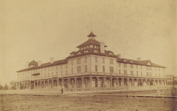 View of the original Hotel Chequamegon, built by the Wisconsin Central Railroad interests and opened in 1877. It was built of wood with a wrap around porch on first level and a second level balcony. It faced the bay and had a long series of steps leading to a boat landing. The hotel was condemned as a fire trap and razed in the 1890's.