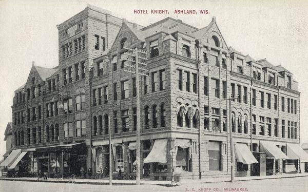 This building was named the Knight Block and contained retail on the first floor, business offices on the second floor and the Knight Hotel on the third, fourth and fifth floors. The fourth floor included a music hall, kitchen, dining room and billiard room. It was built in 1891 of locally quarried brownstone. It was razed in 1974. Caption reads: "Hotel Knight, Ashland, Wis."