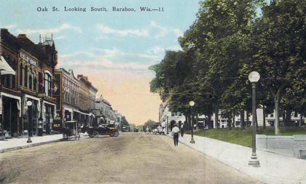 View down Oak Street, with storefronts on the left, and a park on the right. Caption reads: "Oak St. Looking South, Baraboo, Wis."