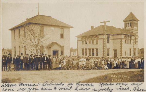 Group portrait of school children lined up in front of Belleville high school. Caption reads: "Bellevilee, Wis. School".