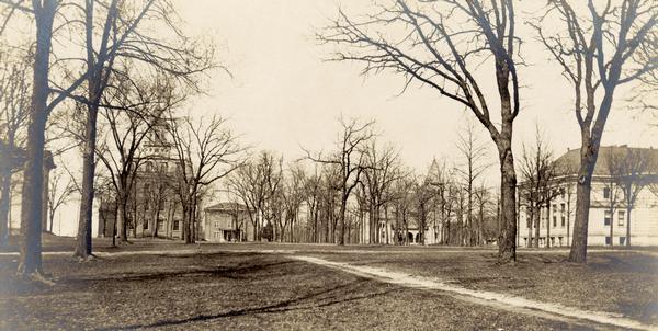 View of Beloit College campus about 1910-1920. A footpath crosses the lawn in the foreground.