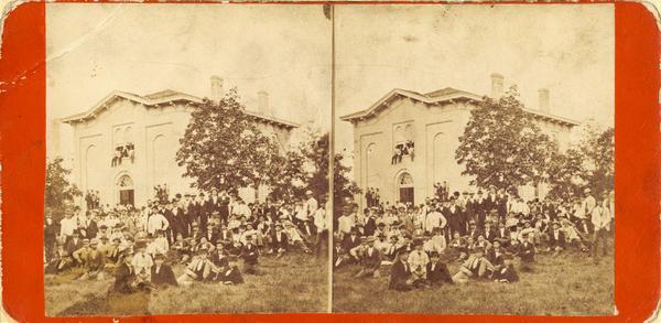 Stereograph view of Beloit College Chapel, with the congregation posed outside on the lawn.