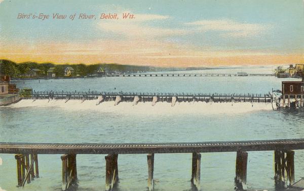 View of the Rock River with the Northwestern Railroad Bridge in the foreground and Beloit in the background. Caption reads: "Bird's-Eye View of River, Beloit, Wis."