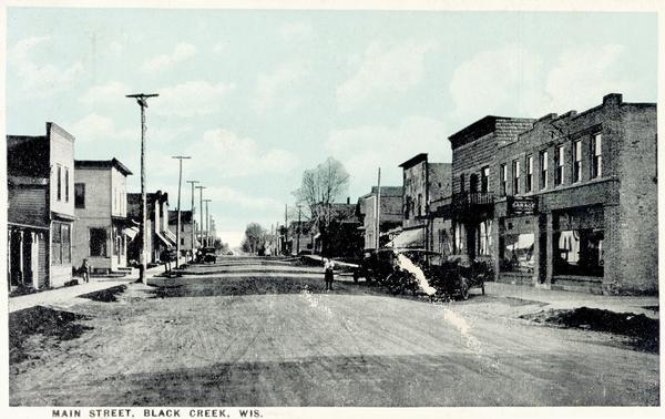 View looking down Main Street with storefronts and power lines lining the street.