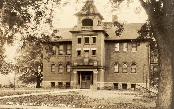 Front view of public school building with playground. Caption reads: "Public School - Black Earth, Wis."
