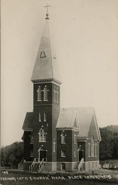 Exterior view of Vermont Lutheran Church with a cemetery in the back. Caption reads: "Vermont Lutheran Church Near Black Earth, Wis."