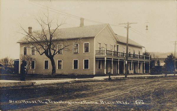 View across unpaved road towards the Blair House. Caption reads: "Blair House, The Travelingman's Home, Blair, Wis."
