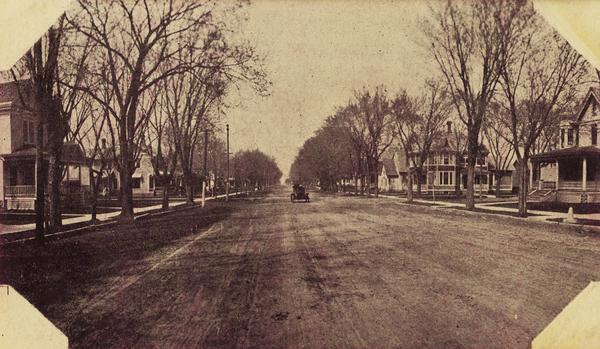 Center Street with houses and trees on both sides, with automobile.