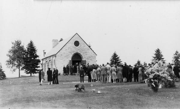 Memorial Chapel, dedicated on May 28, 1939. A large group of people are standing on the lawn in front of the chapel.