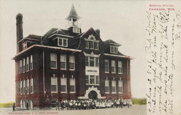 Front view of the Cameron school with a group of children gathered outside. Caption reads: "School House, Cameron, Wis."