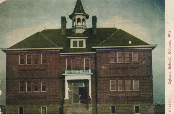 Children are standing near the entrance to the brick school building. Caption reads: "Coloma Schook, Coloma, Wis."