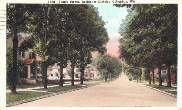 Residence district of James Street. The view is of a wide street with houses on both sides. Caption reads: "James Street, Residence District, Columbus, Wis."
