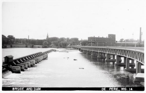 Bridge and dam, with buildings on the far shoreline.