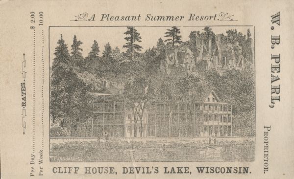 View of the Cliff House on the lake, with pine trees surrounding the property, and a cliff behind the building.