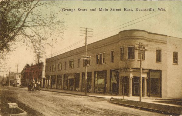 View across street towards the Grange Store. Caption reads: "Grange Store and Main Street East, Evansville, Wis."