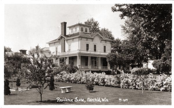 View of the N.C. Foster home. It was built in 1878 and wrecked in 1941. Caption reads: "Residence Scene, Fairchild, Wis."