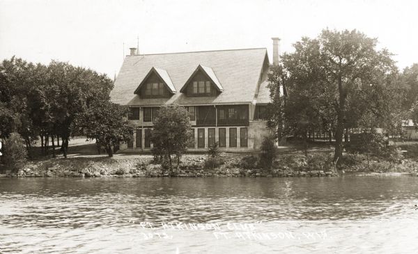 View of the Fort Atkinson Club house from across a body of water. Caption reads: "Ft. Atkinson Club, Ft. Atkinson, Wis."