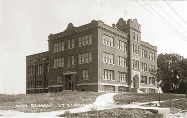 View of the high school with several walkways leading up to it. Caption reads: "'High School,' Ft. Atkinson, Wis."