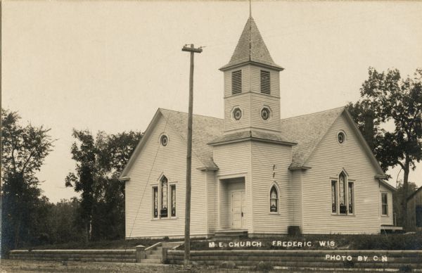 Exterior view of the church. Caption reads: "M.E. Church, Frederic Wis".