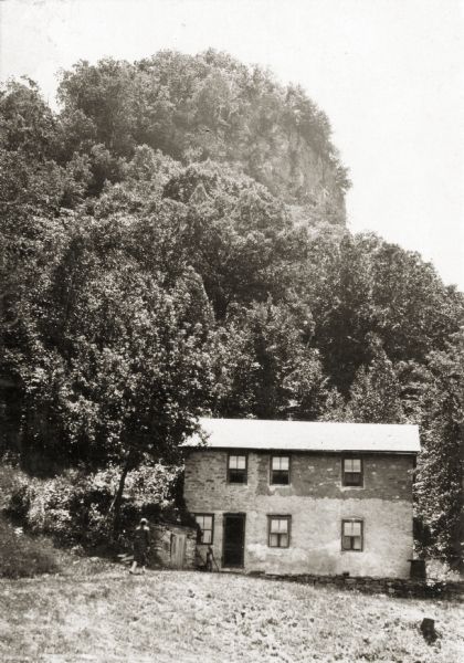 House built by an early Italian settler. At the time of the photograph, the home belonged to Mrs. Margaret Gelarde. Behind the house is a hill and rock formation covered by trees.