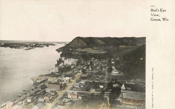 Elevated view of Genoa. Caption reads: "Bird's Eye View, Genoa, Wis." The St. Charles Borromeo Catholic Church is in the right foreground. Railroad tracks run alongside the Mississippi River.
