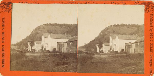Stereograph of buildings in Glen Haven. Bluffs are in the background.