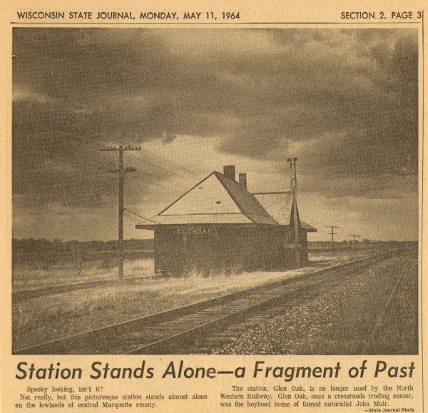 Newspaper clipping of the Glen Oak, Wisconsin train station, a few miles south of Montello on the Chicago and North Western Railway. The caption reads: "Station Stands Along — a Fragment of Past".